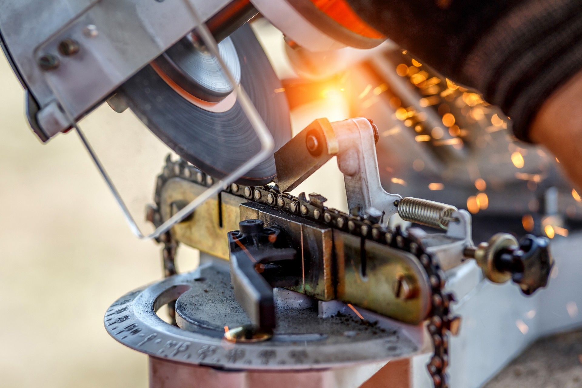 Professional technician working by repair service.Repairing chainsaw in repair shop.Sharpening a chainsaw